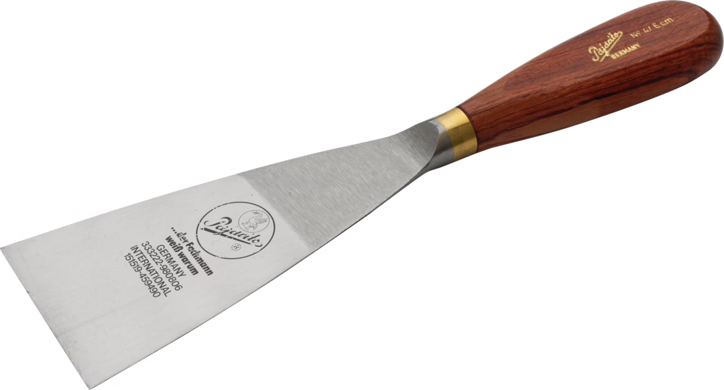 Pajarito_Dummy_Goiter spatula precious wood w brass_034461_034459_060041_060042_060043_034497_2021-02 Stalen plamuurmes met brede rechthoekige plaat en houten handvat met messinghulst; op het blad is het merklogo en een opdruk zichtbaar. Gereedschap om te schrapen en plamuur aan te brengen. Foto op witte achtergrond, schuine weergave.