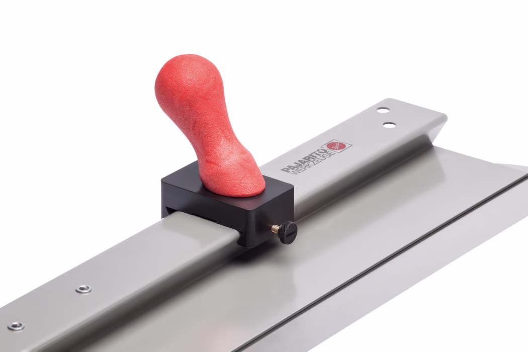 Pajarito_Dummy_Handle knob smoothing spatula_160458_2021-11 Close-up van een metalen afwerkkam met een lang rechthoekig vlak blad gemonteerd op een metalen rail; een rode ergonomisch gevormde zachte handgreep is vastgeklemd in een zwarte kunststof houder met een messing aanschroefbout. Gladde zilvergrijze metalen oppervlakken weerspiegelen studiobelichting; het gereedschap is onder een schuine hoek tegen een witte achtergrond gefotografeerd en toont de structuur van de rode greep en de details van de klem en het blad.