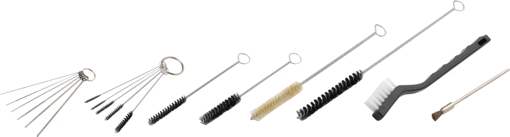 Een horizontale rangschikking van uiteenlopende reinigingsborstels en pijpreinigers op een witte achtergrond. Van links naar rechts: meerdere dunne naaldachtige metalen staven aan een sleutelring, een set van vijf kleine verdraaide microborstels aan een ring, meerdere rechte verdraaide fles- en buisborstels met zwarte of beige haren in verschillende diameters, een lange flexibele borstel met dicht zwarte haren, een zwarte kunststof handgreepborstel met witte nylonharen en een slanke messinggetipte borstel met korte stijve haren. De gereedschappen hebben zilverkleurige metalen stelen en verdraaide draadhendels en zijn bedoeld voor het gedetailleerd reinigen van buizen, mondstukken, kleppen, kleine onderdelen en voor onderhoud van hobby- of instrumenten. De verlichting is gelijkmatig en schaduwen zijn minimaal, waardoor vorm, textuur en haren duidelijk zichtbaar zijn.