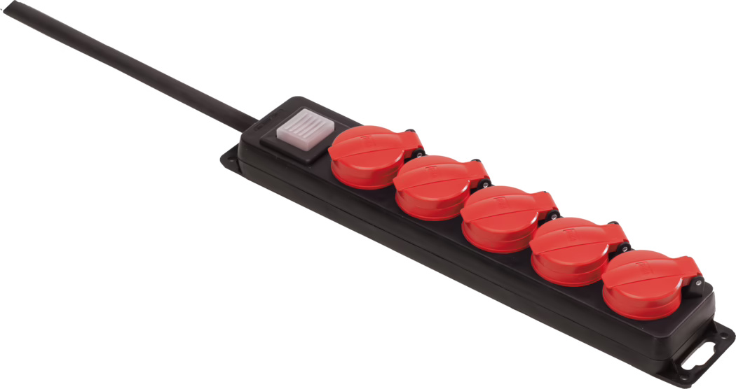 Een zwarte stekkerdoos met een lange zwarte kabel aan de linkerkant, voorzien van vijf rode scharnierende beschermkappen over de stopcontacten en een rechthoekige wit-transparante aan/uit-schakelaar dichtbij de kabel. De stekkerdoos is schuin gefotografeerd op een witte achtergrond; de rode kappen hebben een glanzende afwerking en lijken weerbestendig, en de behuizing is van stevig zwart kunststof met montagegaten aan de uiteinden.