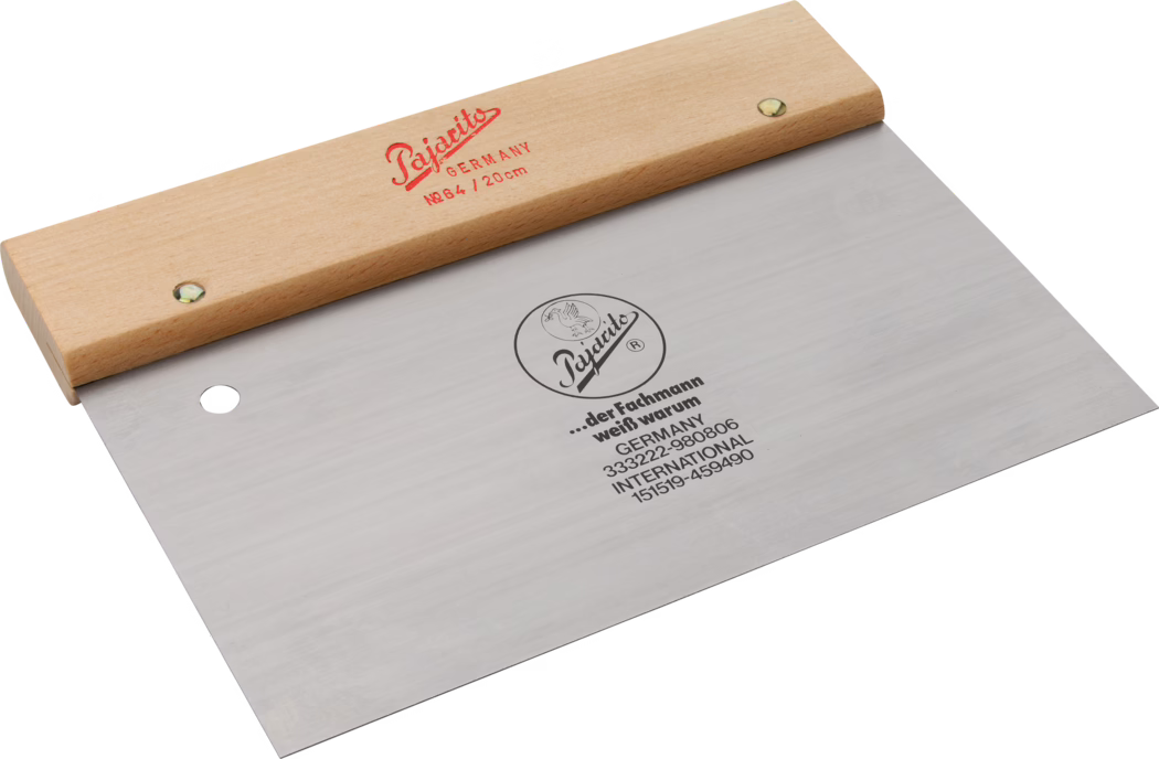 Brede roestvrijstalen plamuurspatel met licht houten handvat dat met twee klinknagels is bevestigd, rode tekst 'Pajacito GERMANY No64 / 20cm' op het handvat en een rond merkembleem op het blad; rechthoekig plat blad met rond ophanggaatje, gebruikt om pleister, lijm of vulmiddel te verdelen en glad te strijken.