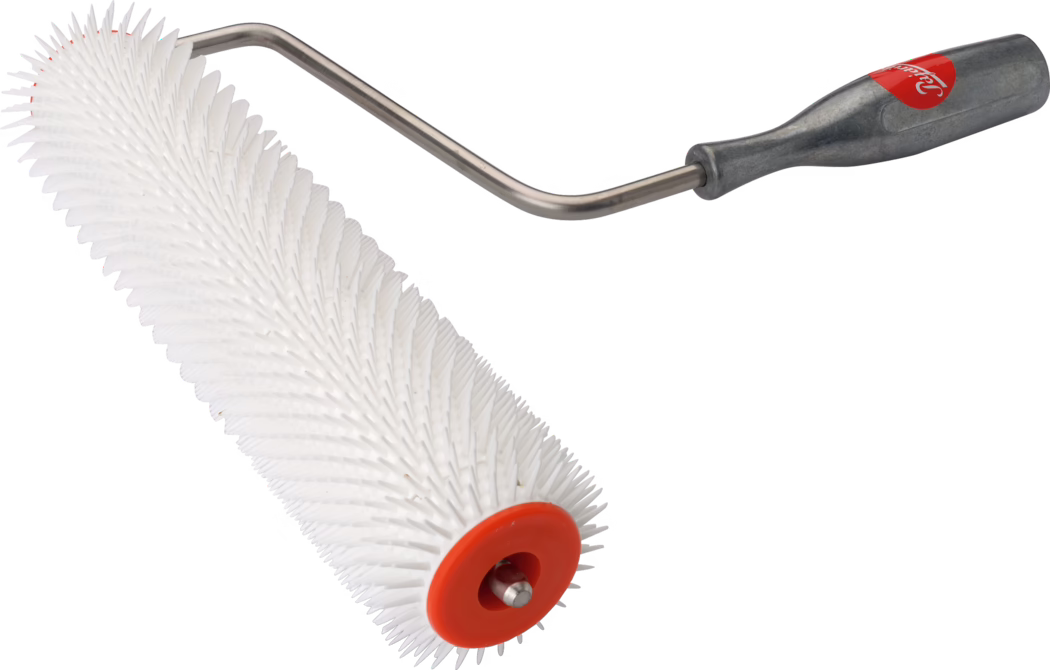 Handzame roller met metalen frame en grijze handgreep, bevestigd aan een lange witte cilindrische kunststofrol die dicht bezet is met korte, gelijkmatig verdeelde kegelvormige stekels. Eén uiteinde van de rol heeft een oranje kunststof afdekking met een zichtbare metalen as in het midden; de foto is genomen op een witte achtergrond en toont fijne oppervlaktestructuur en kleine vlekjes op de rol.